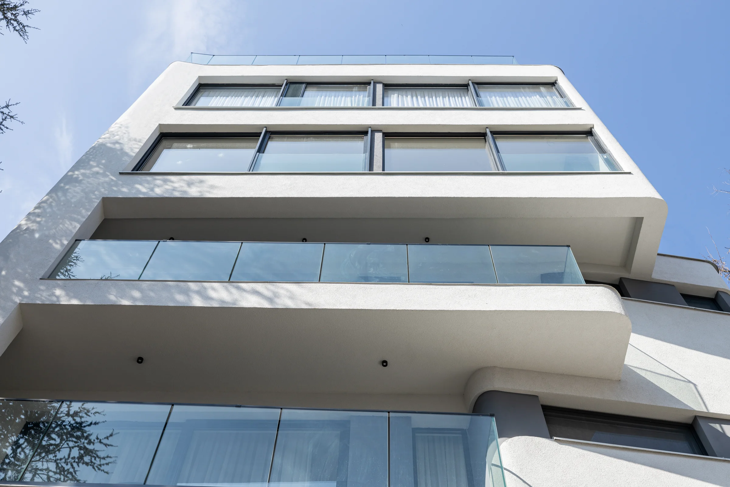 Residential building on Ložnička, Belgrade: glazed upper floors and balconies