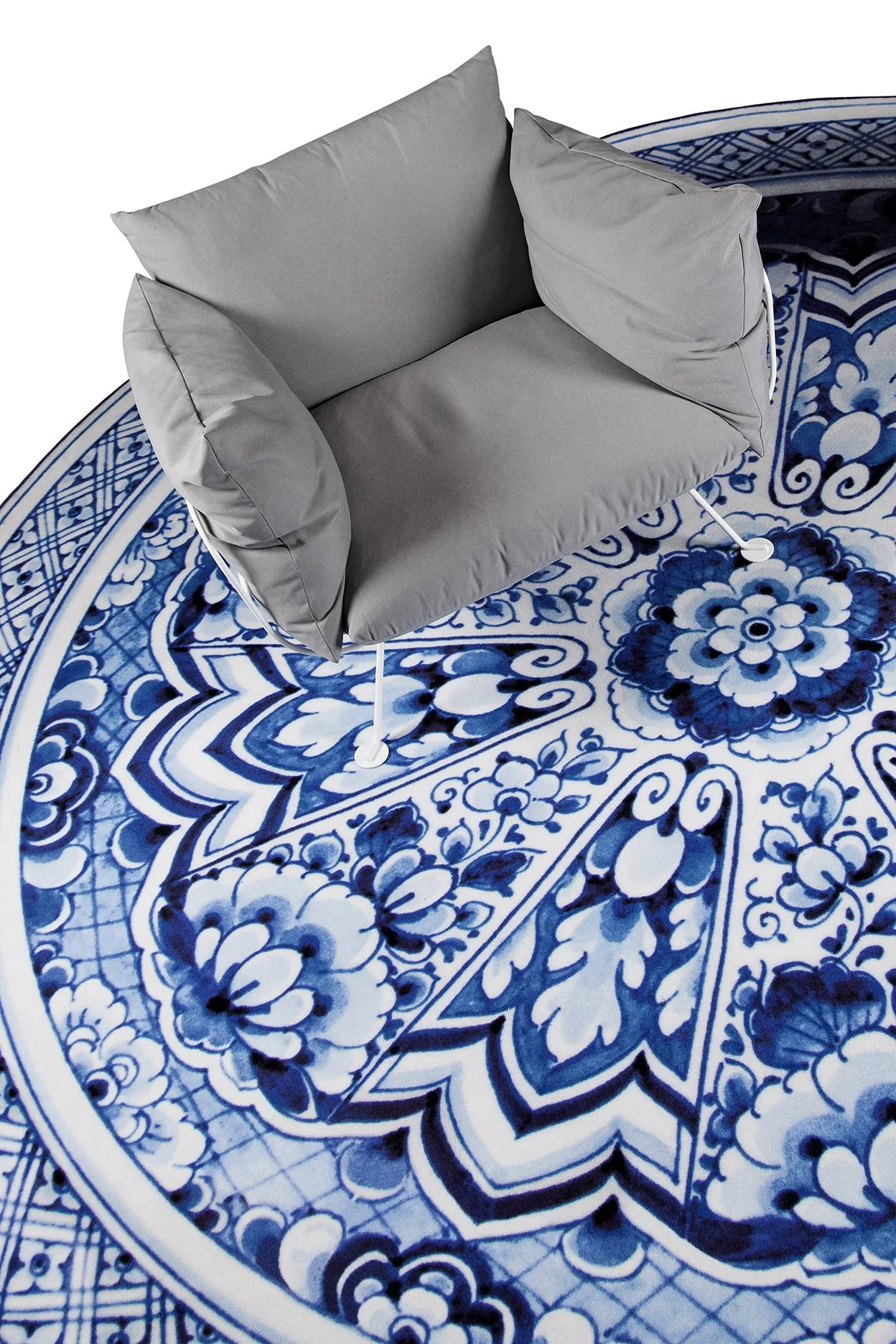 Delft Blue Plate rug by Marcel Wanders for Moooi Carpets with a grey armchair