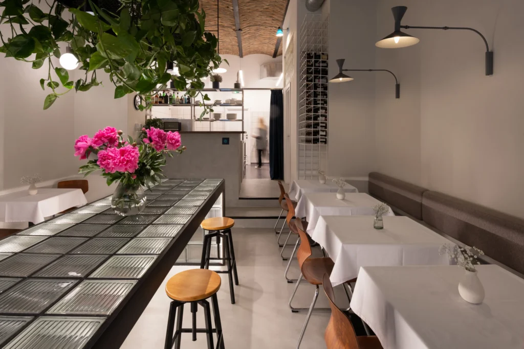 TT Central, Belgrade: the glass-block table with flowers under hanging greenery